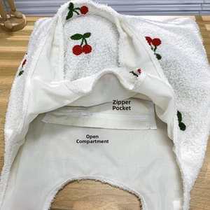 Detailed interior of plush cherry tote bag featuring zipper pocket and open compartment