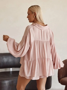 Detail view of blush pink tiered shirt with lantern sleeves and ruffled hem vacation style