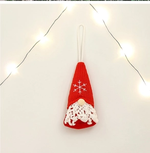 Close-up of a handmade red and white Christmas gnome ornament with festive warm lights