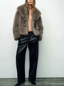 Detail of the brown faux fur jacket texture paired with black leather wide-leg trousers