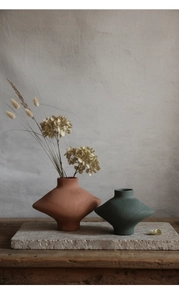 Vue macro de vases géométriques en céramique avec finition brossée en rouge et vert