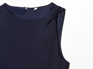 Detail view of the neckline and studded shoulder on this navy blue sleeveless dress