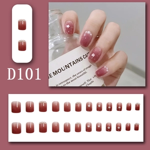 Detail of gradient red press-on nails with 3D white flowers and tiny pearls