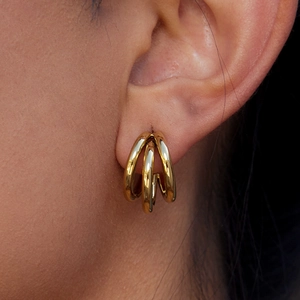 Close-up of triple-layered 14K gold-plated stainless steel C-shaped earrings on model ear