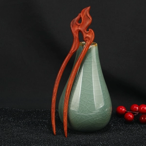 Detailed close-up of dark sandalwood hair stick with exquisite flame-shaped carvings