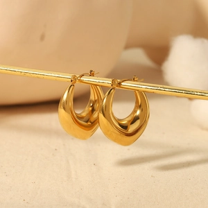 Polished 18K gold-plated chunky teardrop hoop earrings on a minimalist display stand