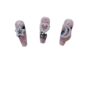Pink resin nail charms with cream white pearl stars, moons, and black heart motifs