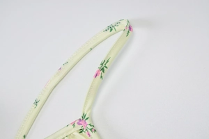 Detailed close-up of adjustable spaghetti straps on a pink floral print summer dress