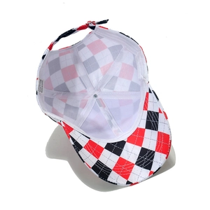 Detail view of the baseball cap's red plaid pattern, inner lining, and adjustment strap