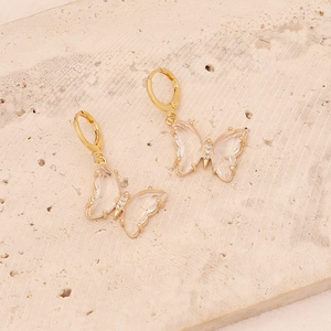 Detail of gold butterfly earrings with transparent wings and micro-pave crystals