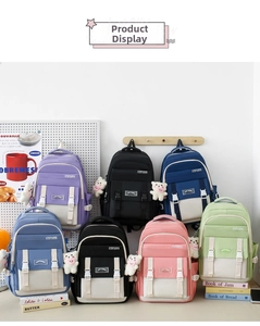 Detailansicht von Canvas-Rucksäcken in sieben Pastellfarben mit Bärenanhängern und Taschen
