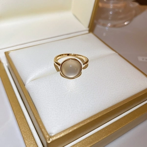 Detailed close-up of a gold ring with cat-eye stone and pearls in a luxury jewelry box