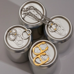 Creative display of soda tab necklaces and earrings on metallic cans showing texture