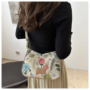 Detail of vintage floral embroidery on linen tote bag with adjustable canvas strap