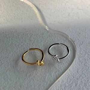 Anelli minimalisti con nodo in argento sterling S925 color oro e argento su sfondo bianco