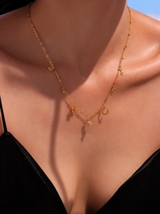 Detailed shot of golden necklace with heart, dolphin, and zircon charms on model