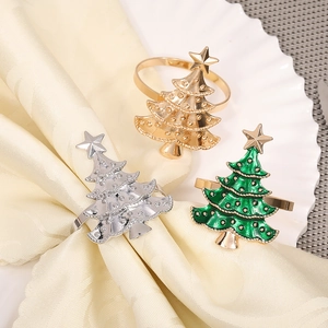 Detailed close-up of festive Christmas tree napkin rings in gold, silver, and green enamel