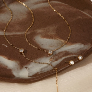 Elegant gold stainless steel jewelry set with solitaire zircon necklace and stud earrings