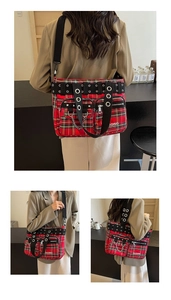 Close-up of red plaid tote bag featuring punk metal rivets and black webbing straps