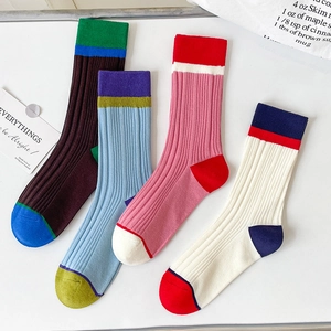 Detail view of four pairs of colorful ribbed cotton socks with vibrant color-block stripes