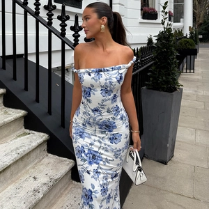 Detail showing the floral print texture and off-shoulder knot design on the white dress