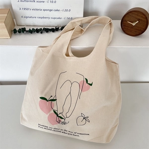 Detail of canvas bag featuring minimalist doodle art and quote in lifestyle setting