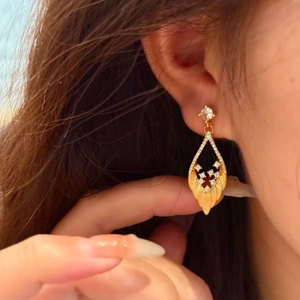 Boucles d'oreilles pendantes en feuille d'or avec diamants et esthétique de palais rétro