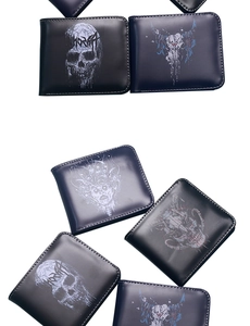 Flat lay showing multiple men's skull print wallets in black and navy blue PU leather