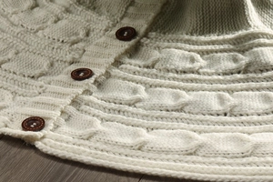 Close-up of cable knit Christmas tree skirt with decorative brown wooden buttons