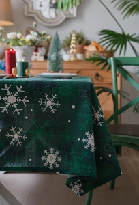 Détail de nappe de Noël verte avec motifs flocons et finitions de couture soignées
