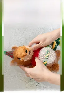 Washable Christmas plush dog toy being hand cleaned in soapy water for hygiene