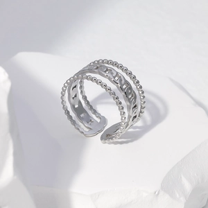 Detail of silver adjustable open chain ring with beaded texture on white stone base