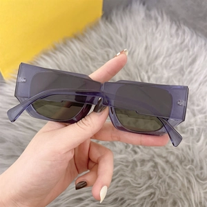 Close-up of stylish rectangular sunglasses with translucent purple frames and grey lenses