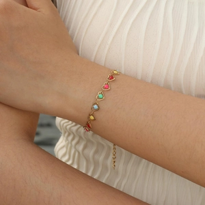 Detail of colorful enamel heart charms on a gold stainless steel adjustable chain bracelet