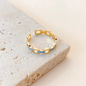 Detailed macro shot of 18K gold chain link ring with light blue enamel on stone