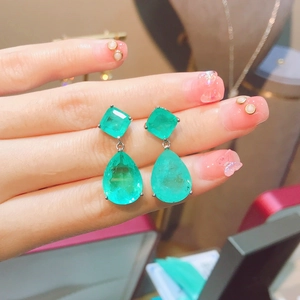 Eleganti orecchini a goccia verde smeraldo con pietre taglio quadrato e a goccia in mano
