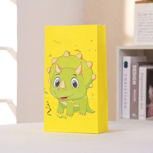 Détail d'un sac cadeau en papier dinosaure jaune avec tricératops mignon et des confettis
