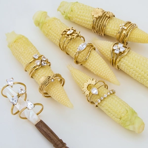 Detailed set of gold-plated stainless steel rings with zircon stones on creative display