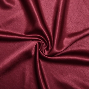 Close-up of elegant wine red satin fabric showing smooth texture and draped silk ripples