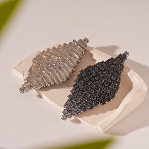 Detail view of rhombic stud earrings with pavé rhinestones in silver and gun black finish