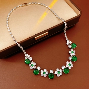 Detail of flower necklace with green and white zircons on silver tennis chain