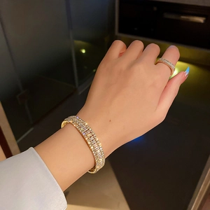 Ensemble luxueux de bracelet et bague dorés avec pavé de zircons brillants scintillants