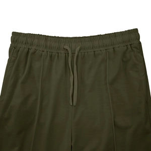 Detail of army green casual trousers featuring an elastic drawstring waistband with texture