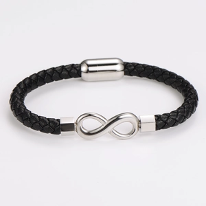 Detail of black braided leather bracelet with silver infinity symbol and magnetic clasp