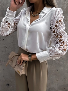 Detail of elegant white satin blouse featuring intricate lace sleeves and pearl-like finish