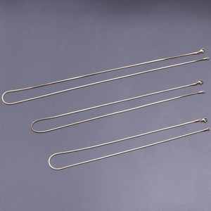 Detailansicht von drei goldenen Schlangenkettchen mit Karabinern in verschiedenen Längen