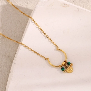 Detail of 18K gold-plated U-ring necklace with a heart pendant and green beads
