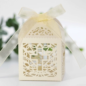 Detailed close-up of hollowed-out cross candy box with ribbon for wedding favors