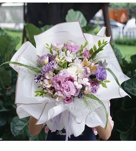 Detalle de papel de regalo floral impermeable con borde dorado para ramos de flores