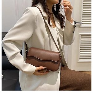 Detailed close-up of brown PU leather texture and flap design on a minimalist crossbody bag